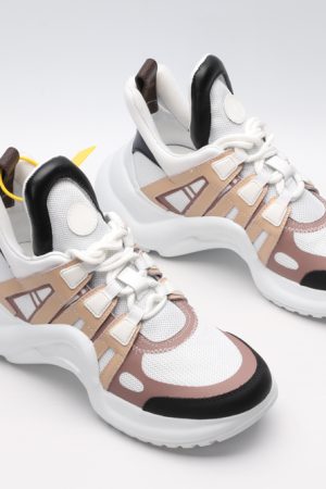 A pair of white chunky athletic sneakers with beige and light brown overlays
