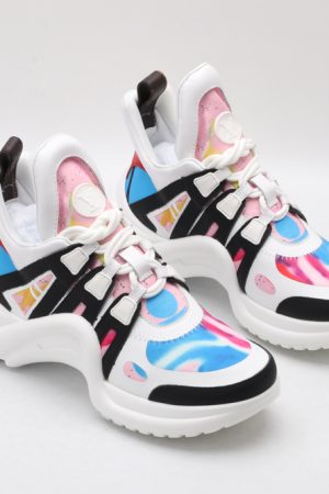 A pair of white chunky athletic sneakers with vibrant pink and blue swirl graphics