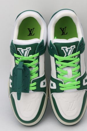 A pair of white low-top sneakers with bold green overlays